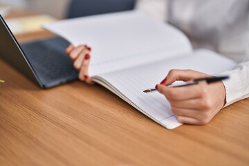 Canvas Print - Young caucasian woman writing on notebook at office