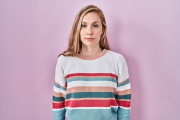 Poster - Young blonde woman standing over pink background relaxed with serious expression on face. simple and natural looking at the camera.