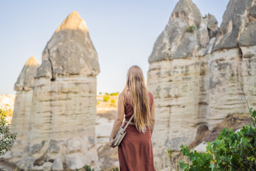Wall Mural - Woman tourist on background of Unique geological formations in Love Valley in Cappadocia, popular travel destination in Turkey