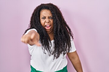 Poster - Plus size hispanic woman standing over pink background pointing displeased and frustrated to the camera, angry and furious with you