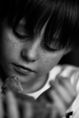  Portrait of boy with Red bearded Agama iguana. Little child playing with reptile. Selective focus. Black and white photography. High quality photo