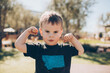 © kristineldridge - toddler boy showing his muscles