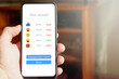 © Eduardo Accorinti - Hand holding smartphone with social media report, analytics chart with icons showing negative red statistics of reach and engagement. Social media profile losing engagement, low interaction.