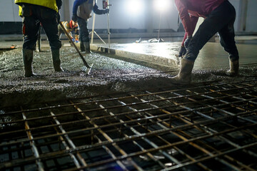 Workers pour concrete floor. Construction of an industrial building