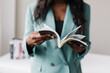 Black businesswoman in suit flipping through book