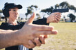 © Azee Jacobs/peopleimages.com - Man, woman and gun training with aim, outdoor target or hand position at police, army or security academy. Shooting coach, pistol or firearm for sport, safety or combat exercise in nature for vision