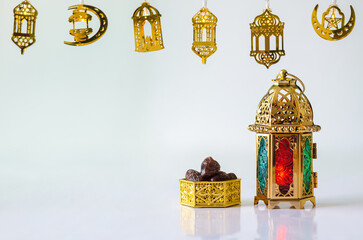 Wall Mural - Golden lantern with dates fruit on white background with decorated lights for the Muslim feast of the holy month of Ramadan Kareem.