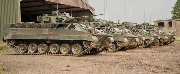 a row of five British army Warrior FV510 fighting vehicles ready for military deployment, Wilts UK