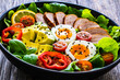 Tasty salad - roasted veal loin, avocado, boiled eggs and fresh vegetables on wooden table
