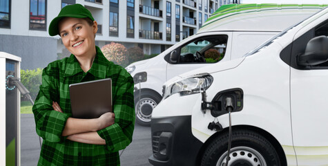 Poster - Woman with a digital tablet stands next to electric delivery van at electric vehicle charging station	