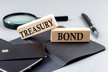 Poster - TREASURY BONDS text on wooden block on black notebook , business concept