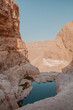 Breicaht Tsfira or Tzfira Pool and Waterfall Lookout.  Negev Desert trail near Arad and Kfar Hanokdim, Southern District of Israel. Hiking Holyland. jagged cliff edges and sand colored mountains 