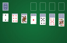 Playing Solitaire On Green Background With Standard Playing Cards