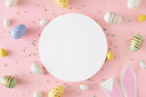 Fototapeta Kawa jest smaczna - Easter decor concept. Flat lay photo of white circle easter bunny ears yellow blue white and green eggs sprinkles on pastel pink background with blank space