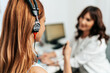 © Dusko - Audiologist doing impedance audiometry or diagnosis of hearing impairment. An beautiful redhead adult woman getting an auditory test at a hearing clinic.