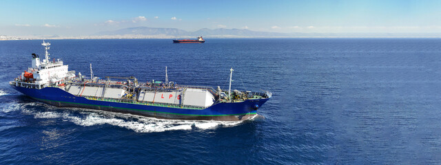 Aerial drone ultra wide top view photo of industrial liquified LPG gas tanker cruising near gas terminal