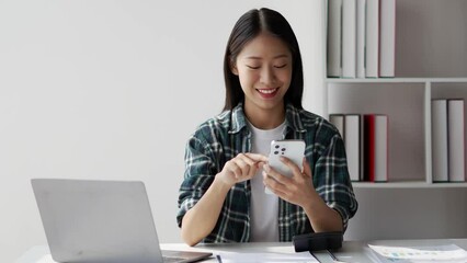 Poster - Young adult smiling pretty woman sitting on chair holding smartphone using cellphone modern technology.
