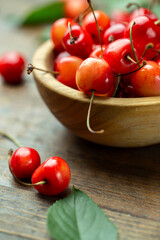 Wall Mural - Fresh cherries with leaves in a wooden bowl