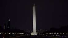 Lockdown Shot Of Washington Monument By Car Moving On Road Against Clear Sky At Night