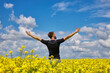 © Ryzhkov Oleksandr - Man stands in a yellow field rejoicing raises his hands to the sky.