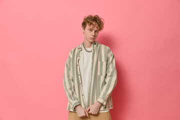 studio fashion portrait of young confident curly haired ginger man with freckles in trendy clothes g