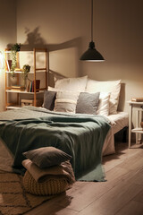 Sticker - Interior of bedroom with cozy blankets on bed and glowing lamp late in evening