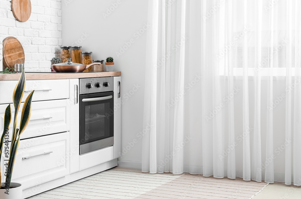 Modern electric oven in interior of light kitchen