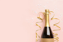 Composition With Bottle Of Champagne, Serpentine And Sequins On Pink Background