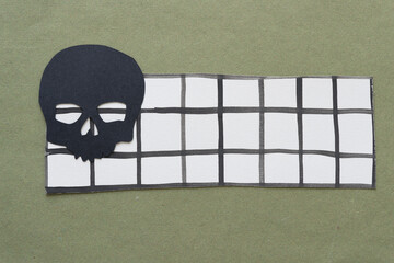 Wall Mural - black paper skull glyph cutout on paper with grid lines