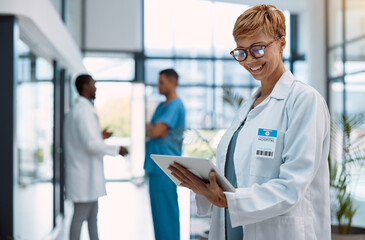 Poster - Woman, doctor and tablet in healthcare research at hospital for innovation, software or schedule planning. Happy female medical professional on touchscreen in online search, browsing or communication