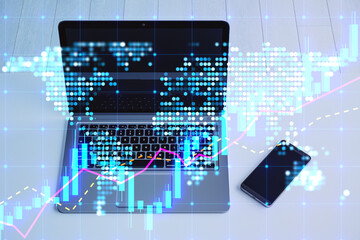 Aufkleber - Close up of laptop and cellphone on desktop with glowing candlestick forex chart map hologram on blurry background. Trade and market concept. Double exposure.