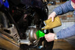 © velimir - pouring new engine oil into a motorcycle engine.