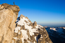 A Climber Stands On A Ledge On Teewinot Mountain, Grand Teton National Park, Wyoming.