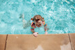 © Cavan Images - young girl holding on to side of pool