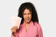 Young african american curly woman holding an hair removal bands isolated screaming very angry and aggressive.