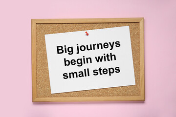 Wall Mural - Corkboard with pinned message Big Journeys Begin With Small Steps on pink background, top view. Motivational quote