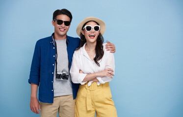 Wall Mural - Excited Asian couple tourist dressed in summer clothes to travel on holidays isolated on blue background.