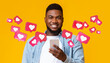 © Prostock-studio - Glad black adult man with beard has romantic chat with hearts on smartphone enjoys message, social networks