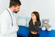 © AntonioDiaz - Sad young girl suffering in pain with a doctor