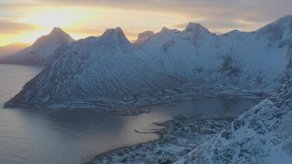 Wall Mural - Breathtaking bird's eye view of high mountain rocky peaks covered with white snow reflected in Norway sea water. Breathtaking panoramic fjords landscape of Senja in winter, calm beauty of nature