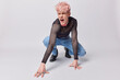 © WHstudio Leushin N - Full length shot of man gay with pink hair squats against white background exclaims loudly has variety of sex characteristics that fall outside traditional stands out from crowd. Nonbinary identity