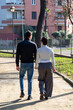 The young couple is holding hands. Young couple is walking in a park in Rome.