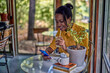 © kerkezz - A happy young woman is drinking coffee at the coffee shop and using a smartphone