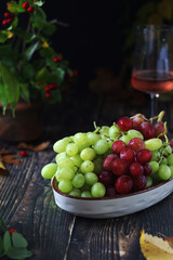 Poster - A bowl with red and green grape in rustic style