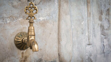 Brass Faucet On A Fountain With Patterned Marble Wall, A Public Bronze Faucet Fountain In The Old Ottoman Traditional Style. Vintage Public Fountain Wallpaper