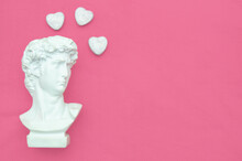 Plaster Male Head With Hearts On A Pink Background. A Postcard With A Place For Text.