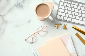 Fototapete - Marble office desk table with coffee cup, keyboard, eye glasses, paper notebooks, office supplies. Flat lay, top view.