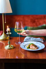 Wall Mural - Salmon steak on the grill on plate on brown table with white wine glass