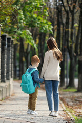 Sticker - Young mom taking her son to school, back view