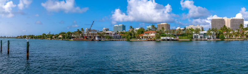 Wall Mural - Biscayne Bay in Miami Beach Florida lined with apartments against blue sky. Scenic view of the Intracoastal Waterway with waterfront residential buildings overlooking a lagoon.